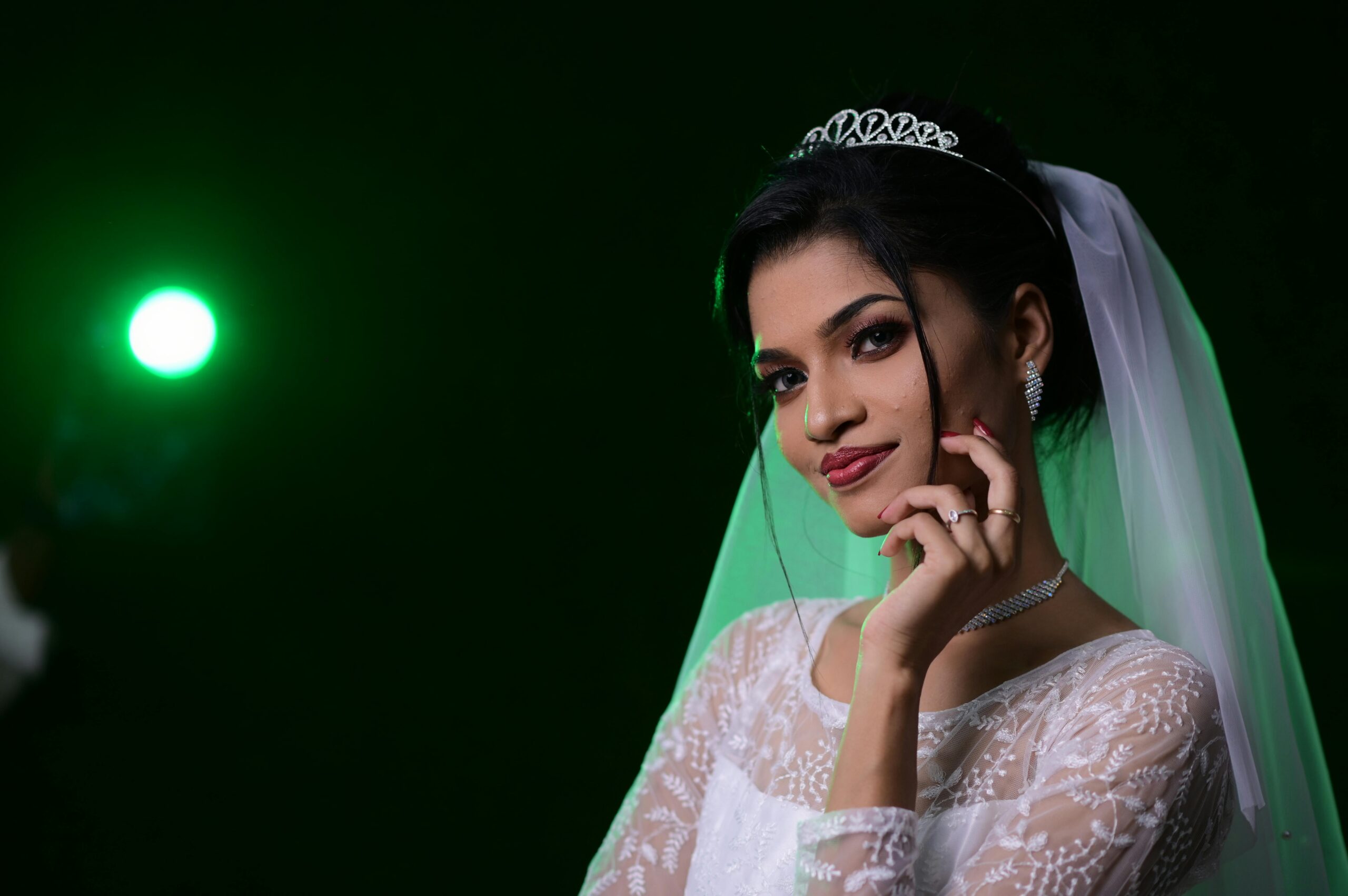 Captivating portrait of a bride in a white dress with a green light effect, perfect for wedding themes.
